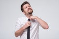 Angry young businessman pulling his tie feeling ill. I need a fresh air. Royalty Free Stock Photo