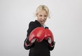 Angry young businesswoman in boxing gloves ready for fight over light grey background, preparing for combat Royalty Free Stock Photo