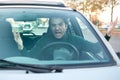 Angry young man driving a vehicle is expressing his road rage Royalty Free Stock Photo