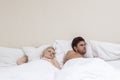 Angry young man ignoring woman in bed Royalty Free Stock Photo