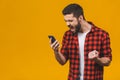 Angry young man screaming on the cell phone isolated on a yellow background Royalty Free Stock Photo