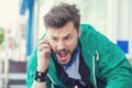 Angry young man screaming on mobile phone outdoors Royalty Free Stock Photo