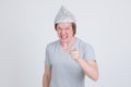 Angry young man wearing tin foil hat as conspiracy theory concept pointing at camera