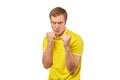 Angry young man in yellow T-shirt ready to fight with fists isolated on white background Royalty Free Stock Photo