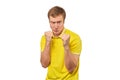 Angry young man in yellow T-shirt ready to fight with fists isolated on white background Royalty Free Stock Photo