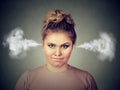 Angry young woman, blowing steam coming out of ears Royalty Free Stock Photo