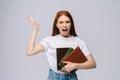 Angry young woman college student holding book and screaming looking at camera. Royalty Free Stock Photo