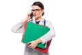 Angry young woman doctor with stethoscope holding binders in her hands and talking on phone in white uniform on white Royalty Free Stock Photo