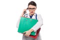 Angry young woman doctor with stethoscope holding binders in her hands and talking on phone in white uniform on white Royalty Free Stock Photo