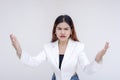 An angry young woman with furrowed eyebrows and arms open wide asking for explanation. Isolated on a white background Royalty Free Stock Photo