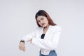 An angry young woman pointing at her watch while looking at the camera. Isolated on a white background Royalty Free Stock Photo