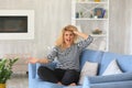 Angry young woman sitting on sofa at home Royalty Free Stock Photo
