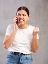 Angry young woman talking on mobile phone