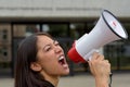 Angry young woman yelling over a megaphone Royalty Free Stock Photo