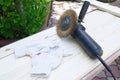 An angular grinder with wire brush on wooden background. Repair tools. Wooden planks