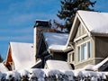 Snow covered roofs of residential dwellings against blue skies