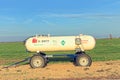 A Anhydrous Ammonia tank in a farm field with a bright blue sky