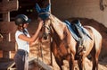 Animal is in blue clothes. Horsewoman in uniform and black protective helmet with her horse Royalty Free Stock Photo