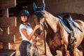 Animal is in blue clothes. Horsewoman in uniform and black protective helmet with her horse Royalty Free Stock Photo