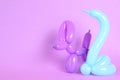 Animal figures made of modelling balloons on color background.