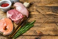 Animal protein sources meat, fish, and poultry. Raw steaks. wooden background. Top view. Copy space Royalty Free Stock Photo