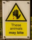 These Animals May Bite Sign in yellow and black on white Royalty Free Stock Photo