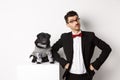 Animals, party and celebration concept. Handsome young man and puppy in formal suits looking at camera, standing over Royalty Free Stock Photo