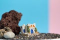 Animated model of a Greek house on a rock on a neon and pink background.