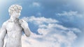 Animation of gray sculpture of man over blue sky and clouds, copy space