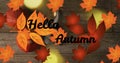 Animation of hellow autumn text over cutlery and autumn leaves over wooden background