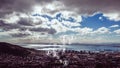 Animation of multiplying people icons moving over cloudy sky, coast and sea