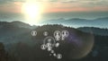 Animation of multiplying people icons moving over idyllic misty mountain landscape at sunset