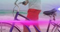 Animation of pink light beam moving over man wheeling bicycle on beach