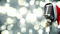 Animation of rerto microphone with santa hat over shining bokeh