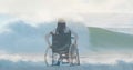 Animation of sea landscape over disabled cuacasian woman sitting in wheelchair