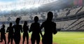 Animation of silhouettes of female athletes over sports stadium