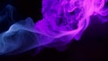 Fluidly moving blue and purple smoke on a black background