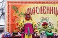 Animator in national costume on the stage with prizes for winning contests.