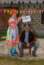 Animator woman holds a leaflet with the word sex in Russian, an old paratrooper with a beard in a blue beret over his head