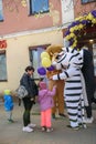 : Animators in a lion and zebra costume from the cartoon Madagascar in the city with children