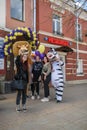 Animators in a lion, zebra and penguin costume from the cartoon Madagascar are photographed with girls on the street