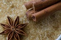 Anise star and cinnamon sticks on brown sugar cane background. Macro view and details of crystal sugar. Top view. Royalty Free Stock Photo