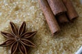 Anise star and cinnamon sticks on brown sugar cane background. Macro view and details of crystal sugar. Top view. Royalty Free Stock Photo