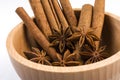 Anise stars and cinnamon sticks in wooden bowl isolated on white background Royalty Free Stock Photo