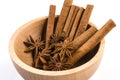 Anise stars and cinnamon sticks in wooden bowl isolated on white background Royalty Free Stock Photo