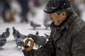 Ankara/Turkey-December 06 2018: Man feeding pigeon on his hand with simit which is Turkish bagel Royalty Free Stock Photo