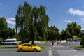 Ankara, Turkey - June 24, 2018: Yellow taxi stands near a beautiful spreading tree near the entrance to the tomb of