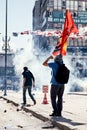 Young protester holding a flag struggling against the tear gas fired by the police during Gezi park protests in Ankara, Kizilay