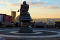 Close-up view stack of books monument in the center of small city square during autumn sunset