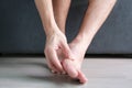 Ankle Pain man sitting on wooden background holding her feet. Health concept Royalty Free Stock Photo